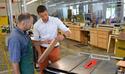 Facebook employee Hans Lintermans receives instruction on how to refine his cutting board.