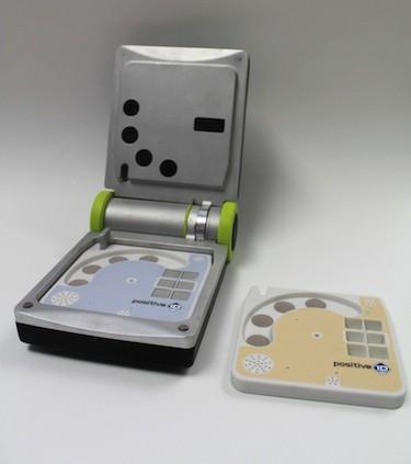 PositiveID has developed a prototype device, the Firefly DX, to conduct quick tests for infectious diseases, including Ebola. The mini-laptop device can be opened to insert testing cartridges inside that include a small hole in the center for taking blood samples. 